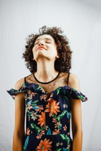 Woman facing up with eyes closed smiling How to thrive as an empath
