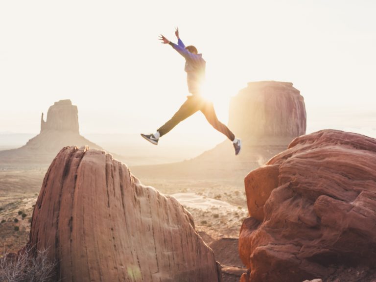 man jumping across large rocks.   Create a vision board on Pinterest