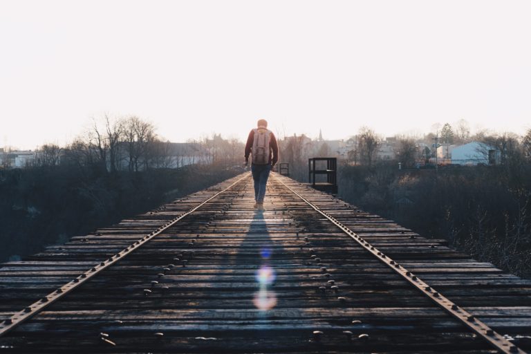 Person walking alone along the train tracks 