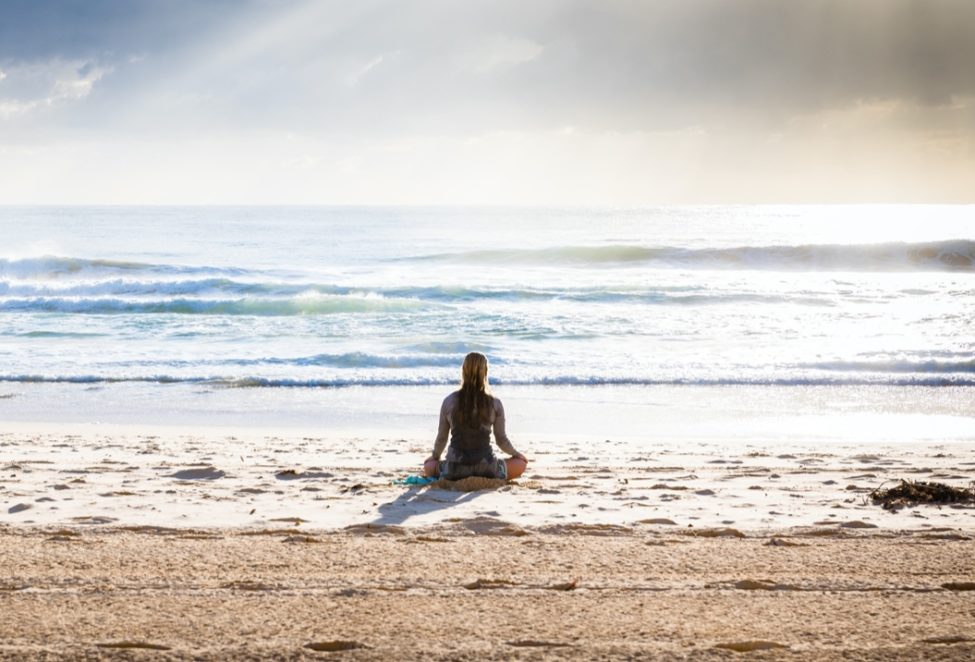 woman sitting on beach being an empath during a pandemic