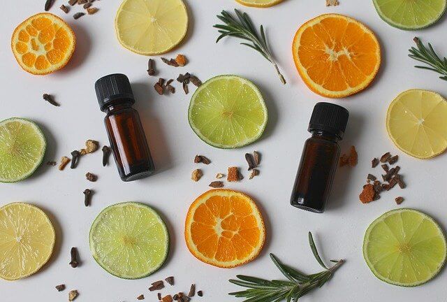 essential oils with orange and lemon slices and scattered herbs