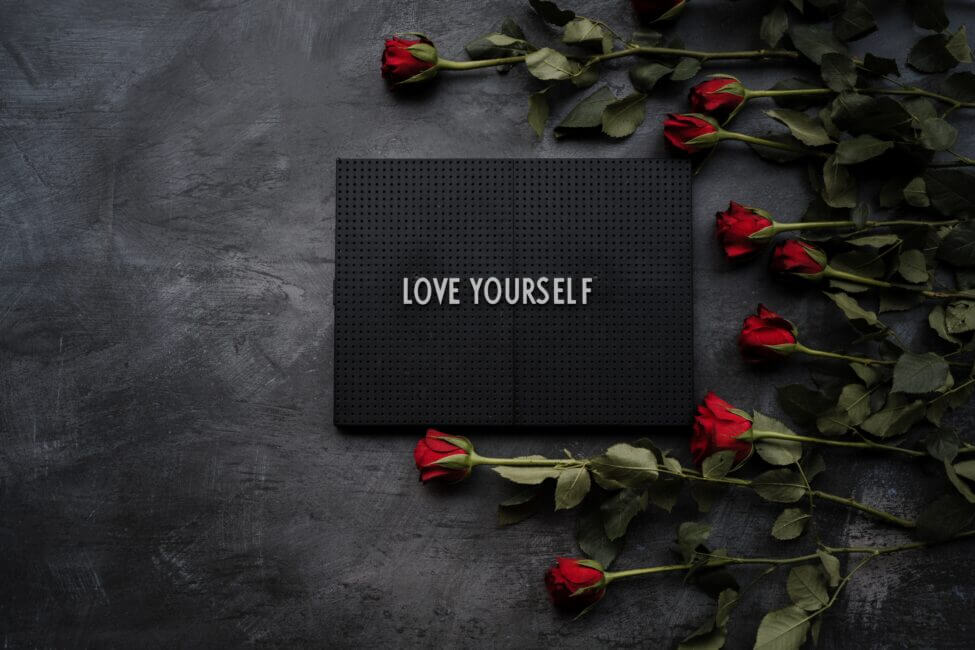 Love yourself sign with red roses self-love