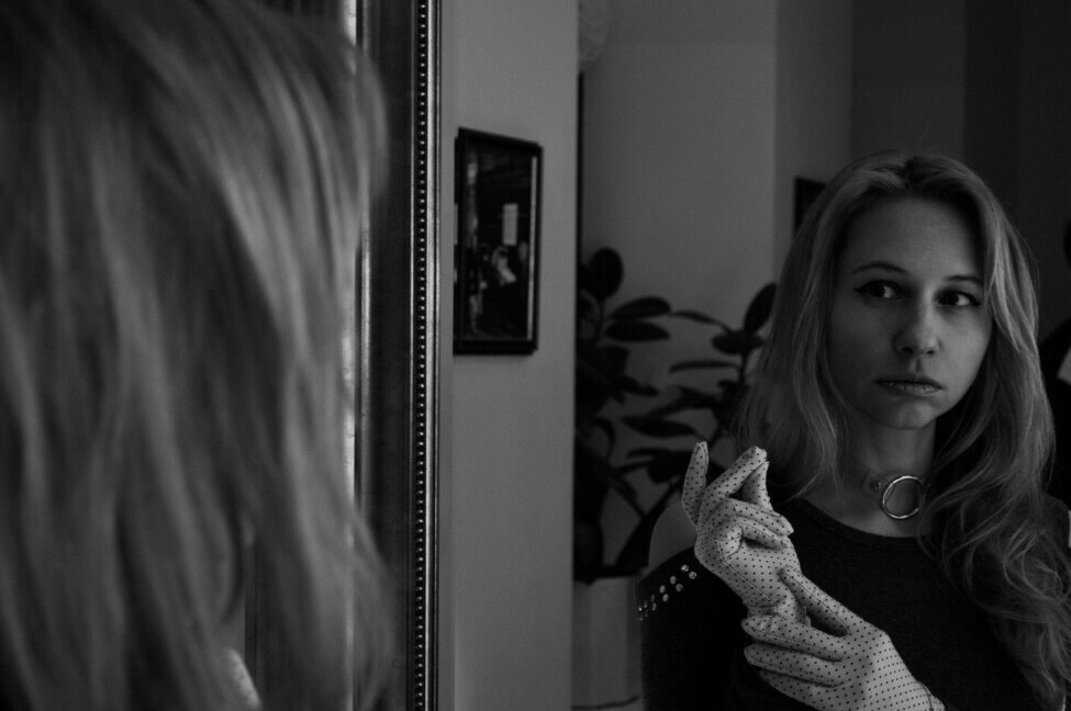 Black and white of woman looking in the mirror inner critic