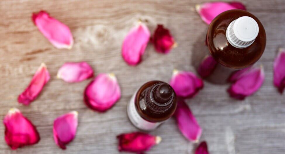 rose petals and essential oil bottles 